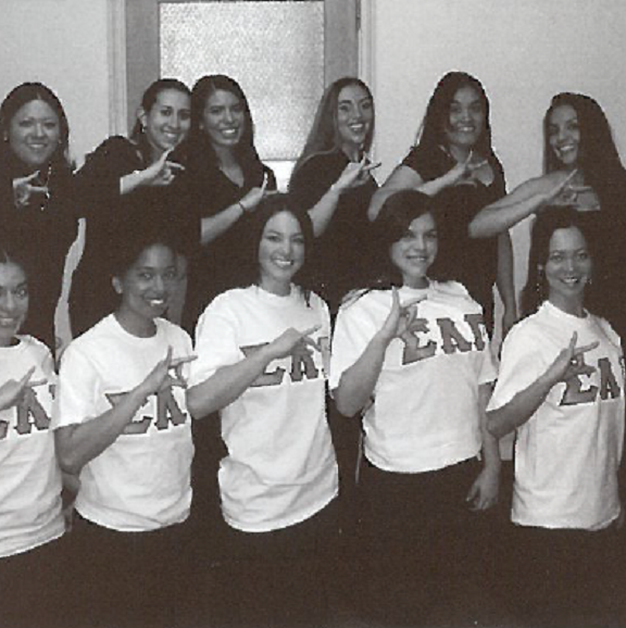 Group photo of women posing showing their sorority hand sign