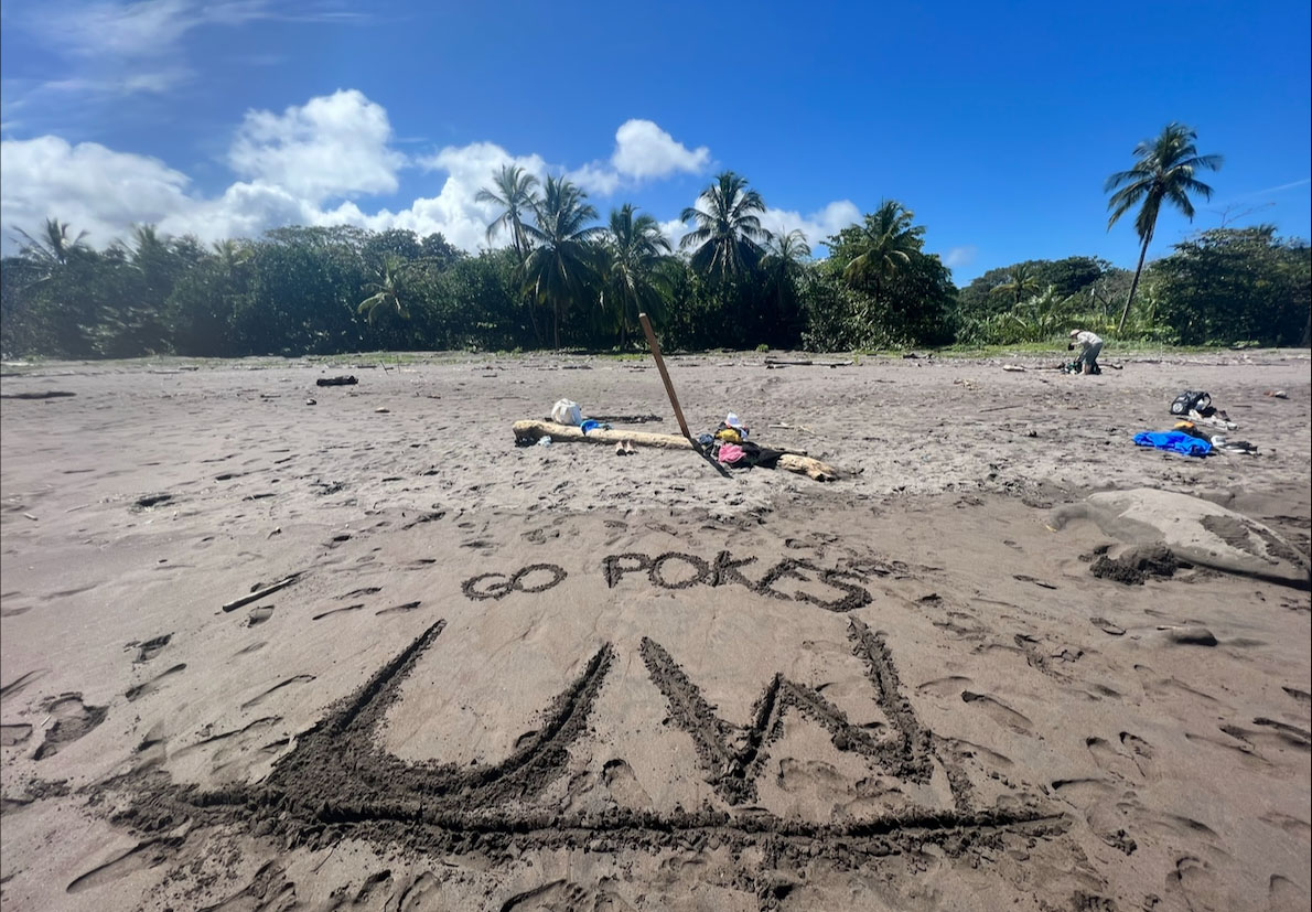"UW Pokes" is written on sand at a beach in Costa Rica during the 2023 FYE Abroad
