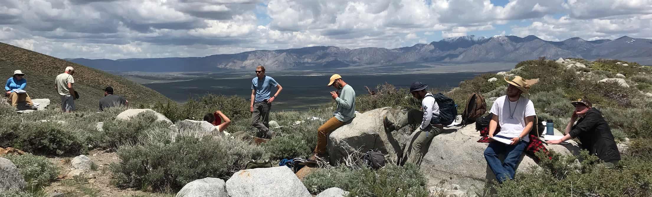 UW geology and geophysics students sitting on rocks at the 2019 field camp