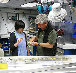 Two researchers examine rocks from the lower ocean crust of the Pacific Ocean.