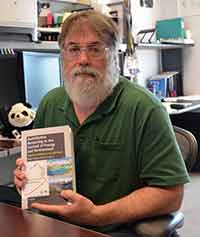 James Myers, holding up the book he co-authored.