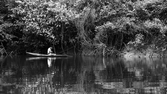 Black and white photo of a boy fishing on the Tahuayo River