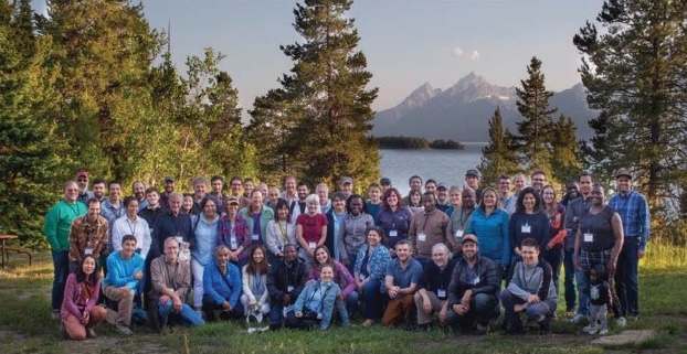 group photo of conference attendees outside, in front of Teton mountains