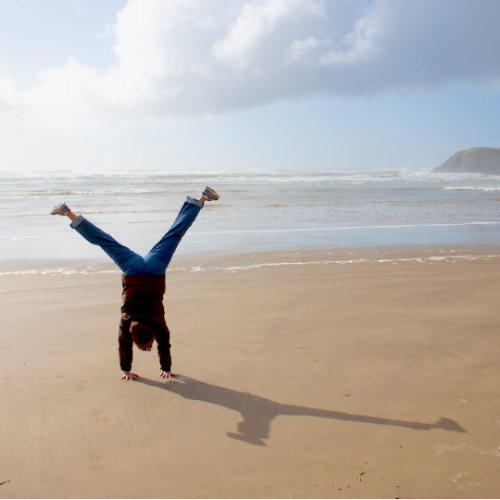 Student cartwheeling on Oregon beach