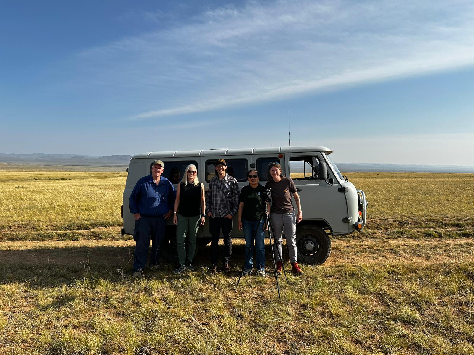 Five Global and ENR representatives in front of a van on Mongolian plains