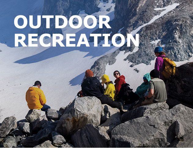 Outdoor Recreation with people sitting on rocks with a mountain in the background