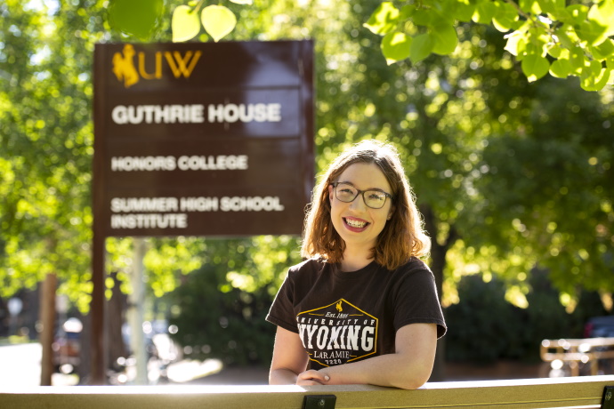 Honors student in front of an Honors sign