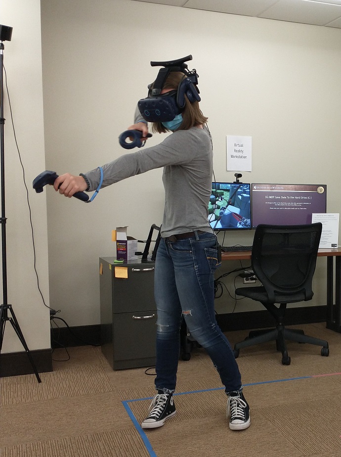 A student experiencing virtual reality with joysticks and goggles
