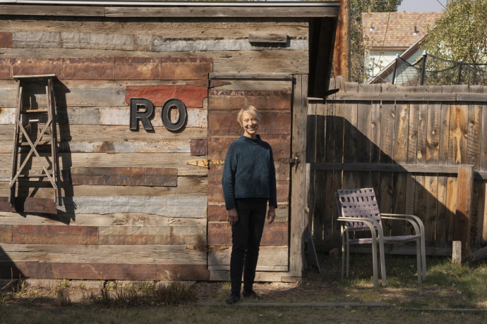Ann McCutchan in front of a wooden building