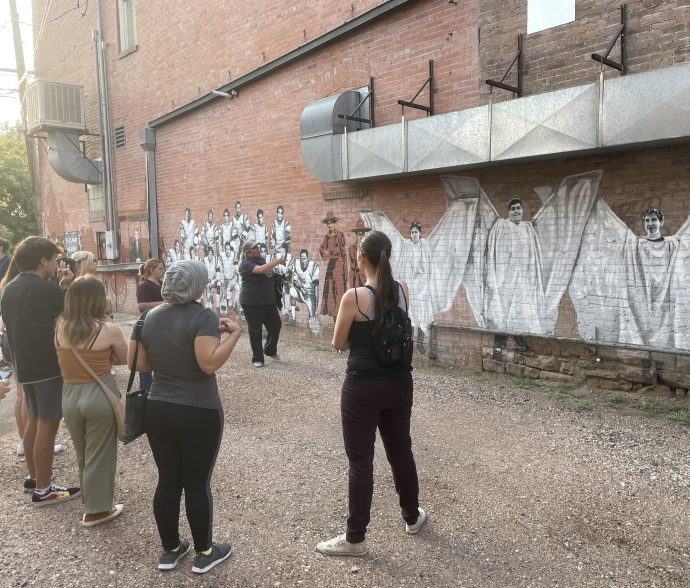 Students standing in front of mural in Laramie