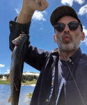 Headshot of Noah Miles holding a fish