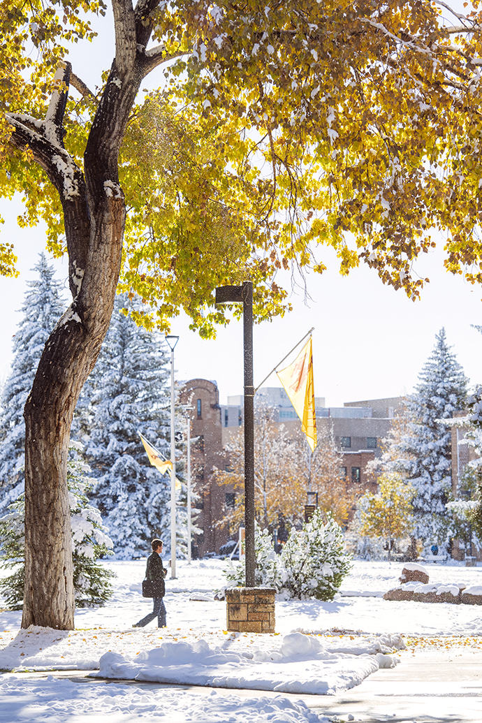 Fall and winter view of campus and a walker