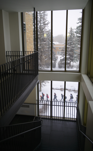 Picture looking through a window at people walking in the snow