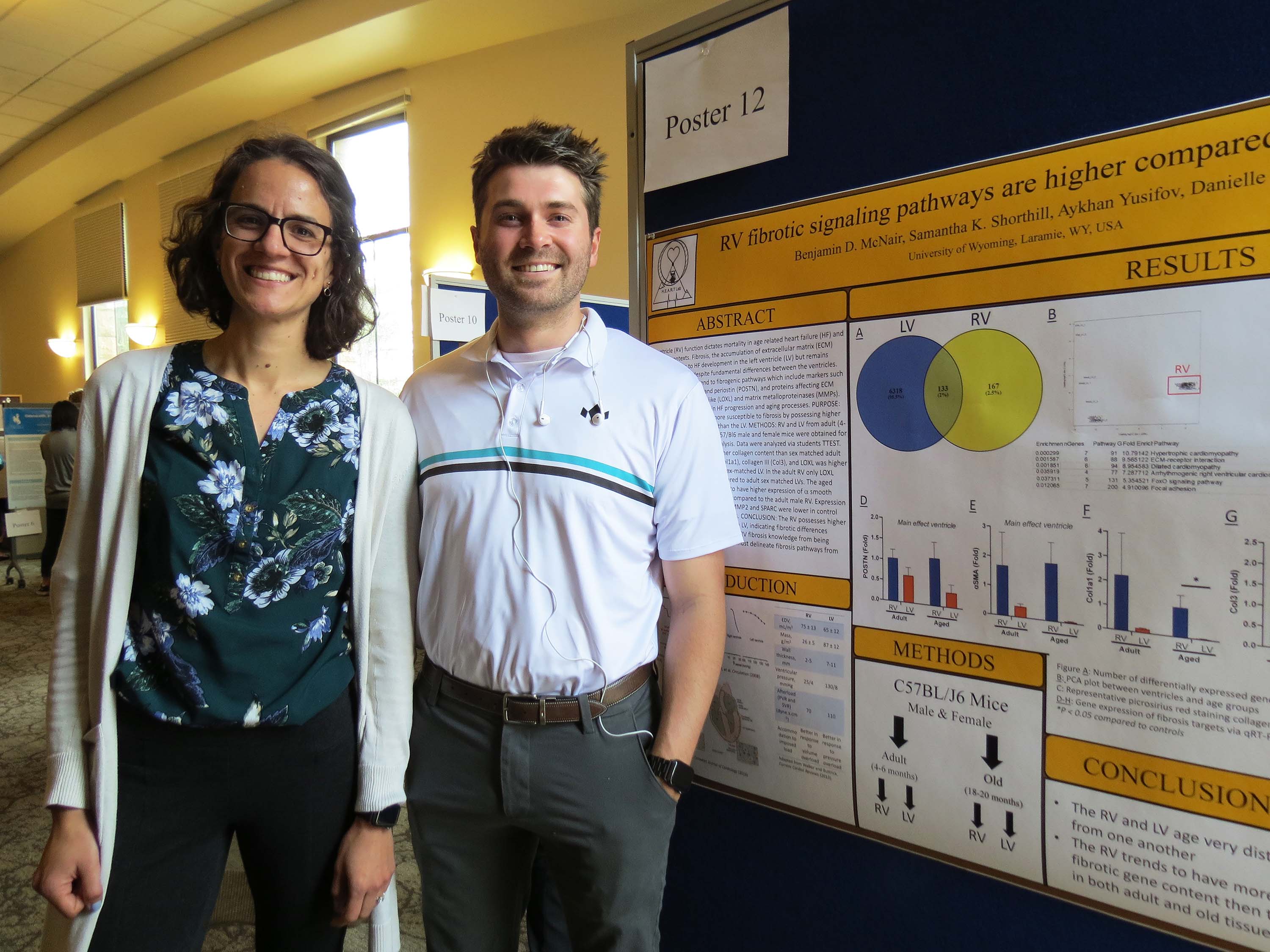 Woman and man standing in front of a research poster.