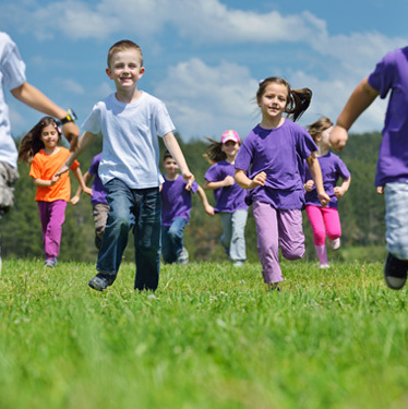 Children running in grass playfield