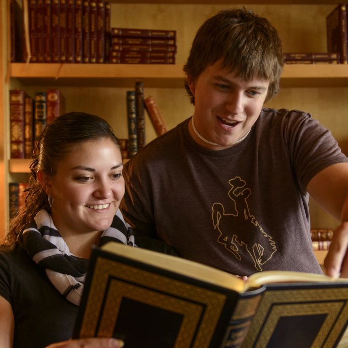 two students reading a book in the McMurry Reading Room