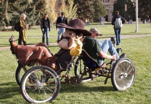 mascot pistol pete rides in moon buggy with mechanical engineering student