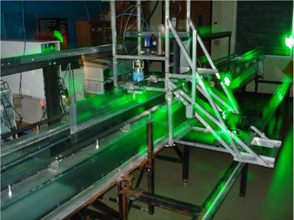 photo of green lasers shining on steel laboratory equipment