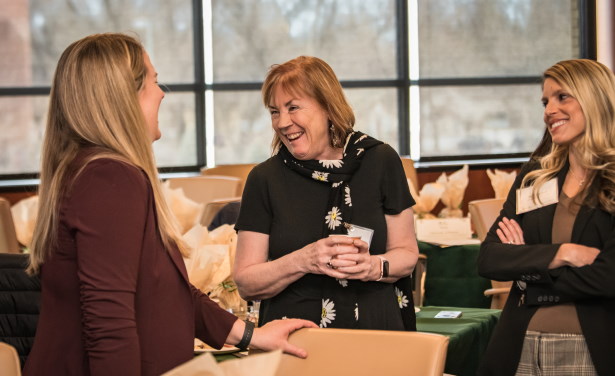 Attendees speaking with each-other at the Mountain West Research Symposium. 