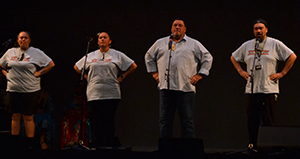 four people on a darkened stage