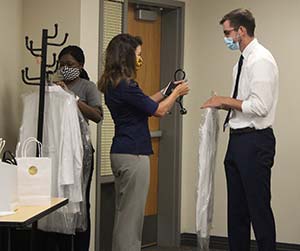 man accepting white coat from woman