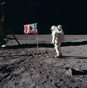 astronaut and U.S. flag on the surface of the moon
