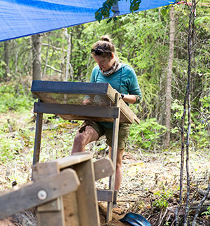 woman screening soil looking for small artifacts