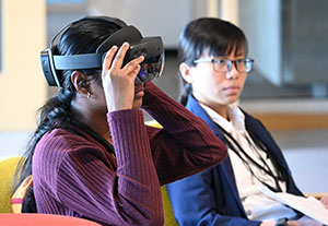 Two students, one wearing VR glasses