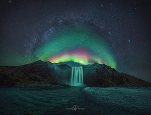 aurora borealis behind a waterfall