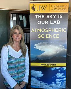 woman standing beside a banner for UW Atmospheric Science