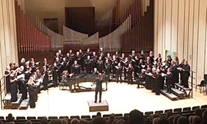 person conducting choir on a stage