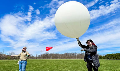 two people launching a large research balloon
