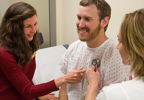UW nursing faculty and student work with stethoscope to asses health of patient