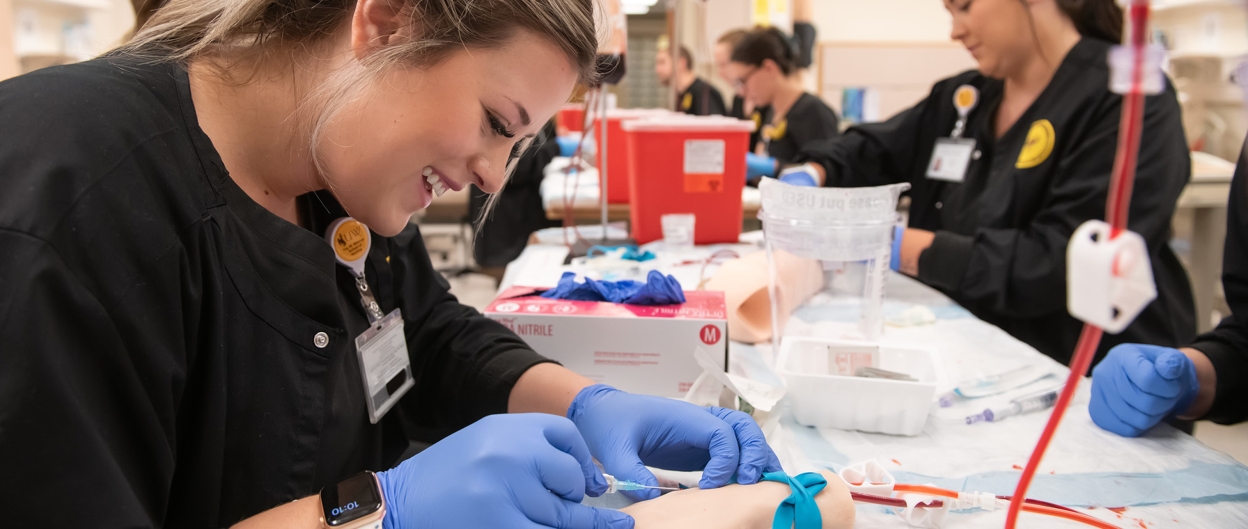 A University of Wyoming student in the nursing program practices medical procedures on a simulator hand.