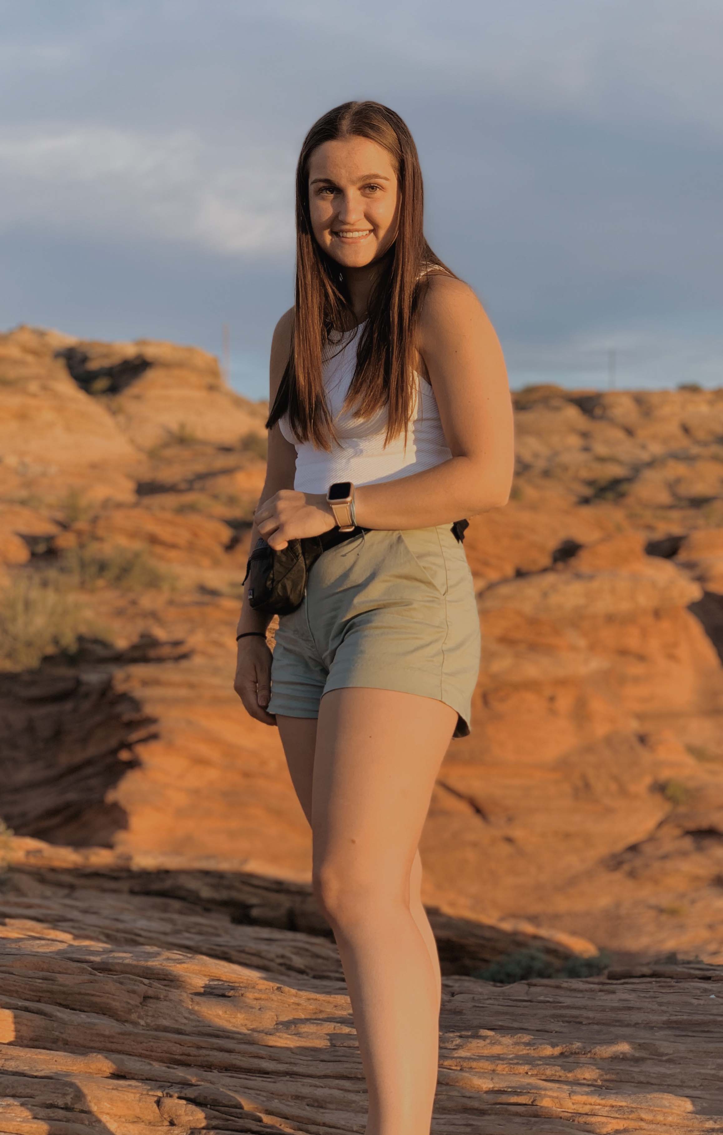 Female student standing in a beach setting.