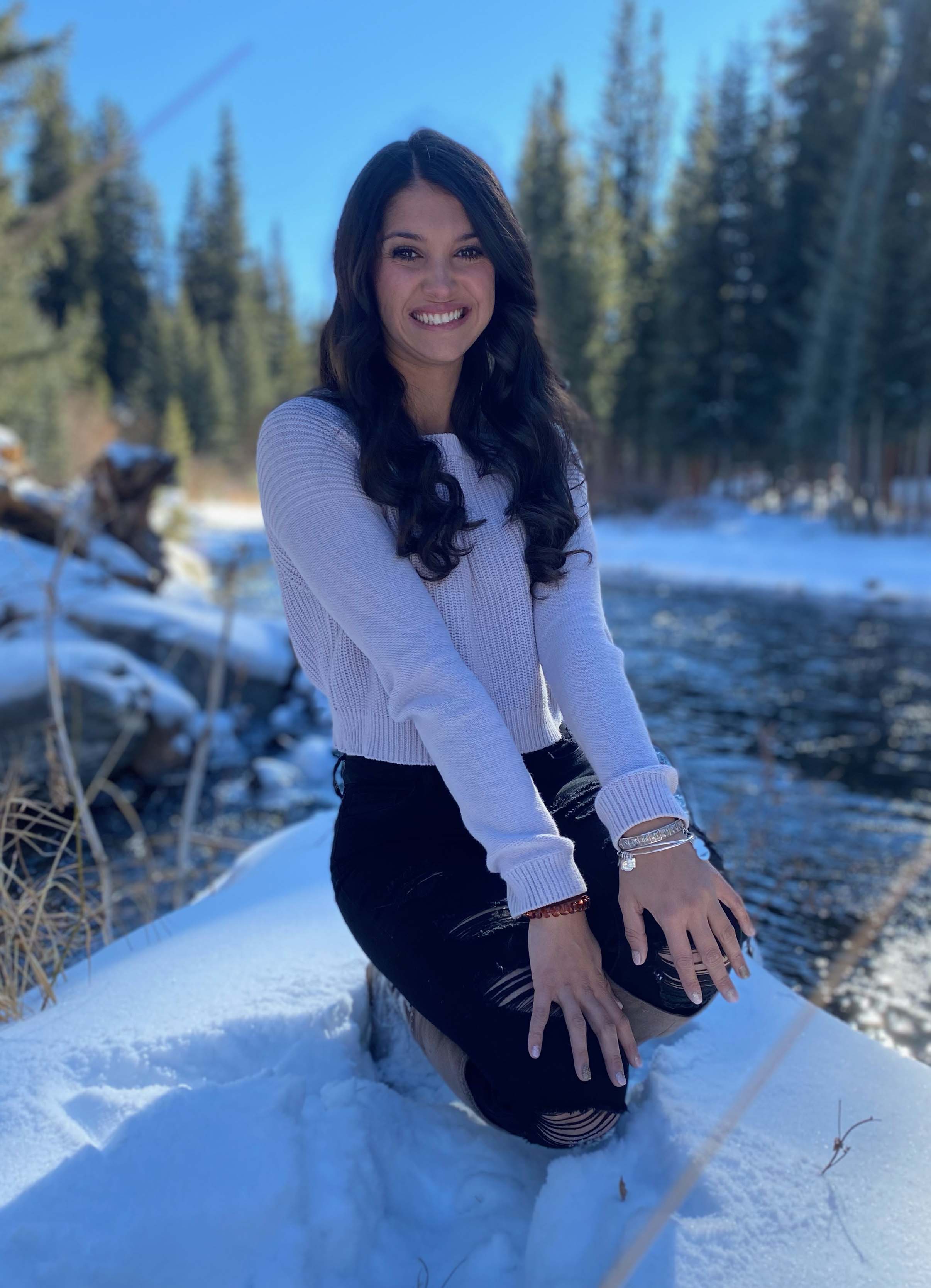 Female students sitting on a snowy hill.