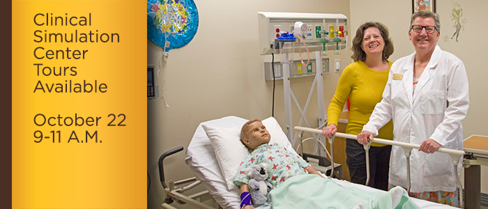 two women stand by pediatric maniken in clinical simulation center