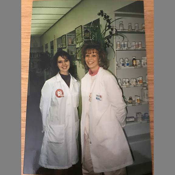 Two pharmacy students wearing their white coats.