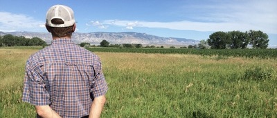 Student surveying field with mountains in background