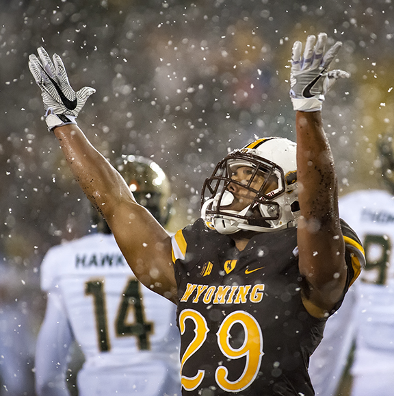 UW football player celebrating on the field with snow falling