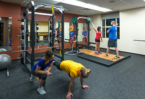 Personal trainers working with clients in the weightroom