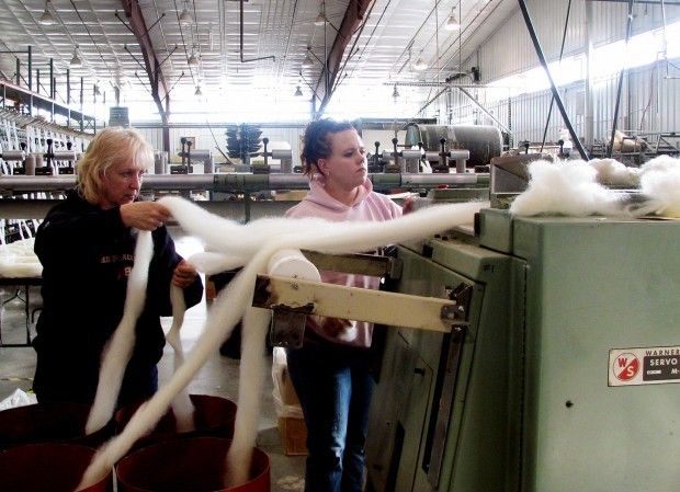 Valerie Spanos of Mountain Meadow Wool feeds wool roving into a spinner