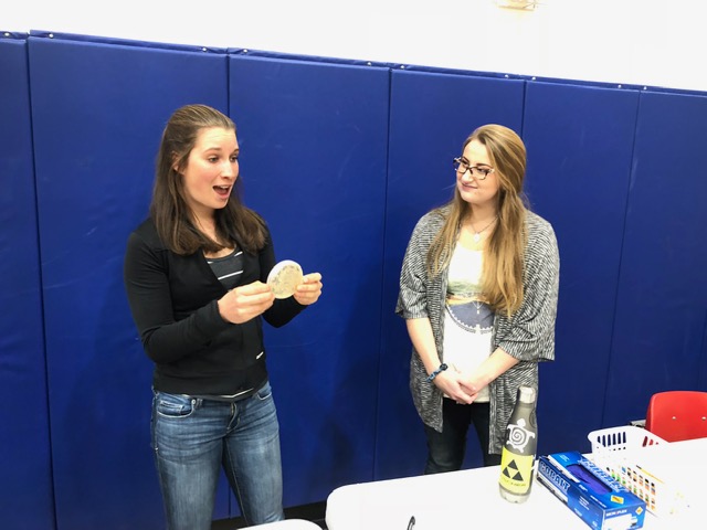 Ella and Mercedes showing students a culture of soil bacteria