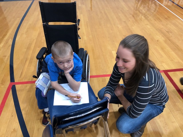 Ella helps a student draw