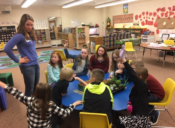 Ella standing in front of a table of students