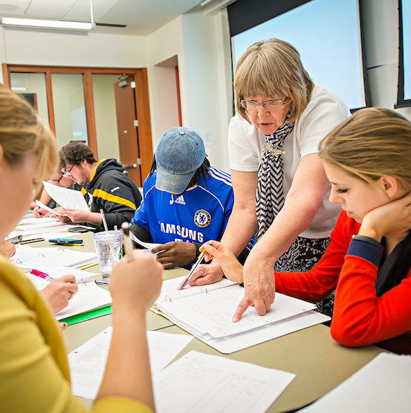 Instructor assists students as they work to solve a problem