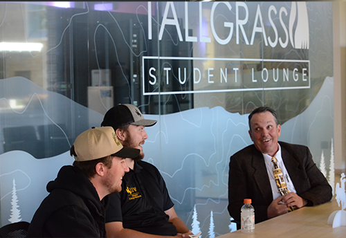 Students speaking to a professor in the Tallgrass Student Lounge