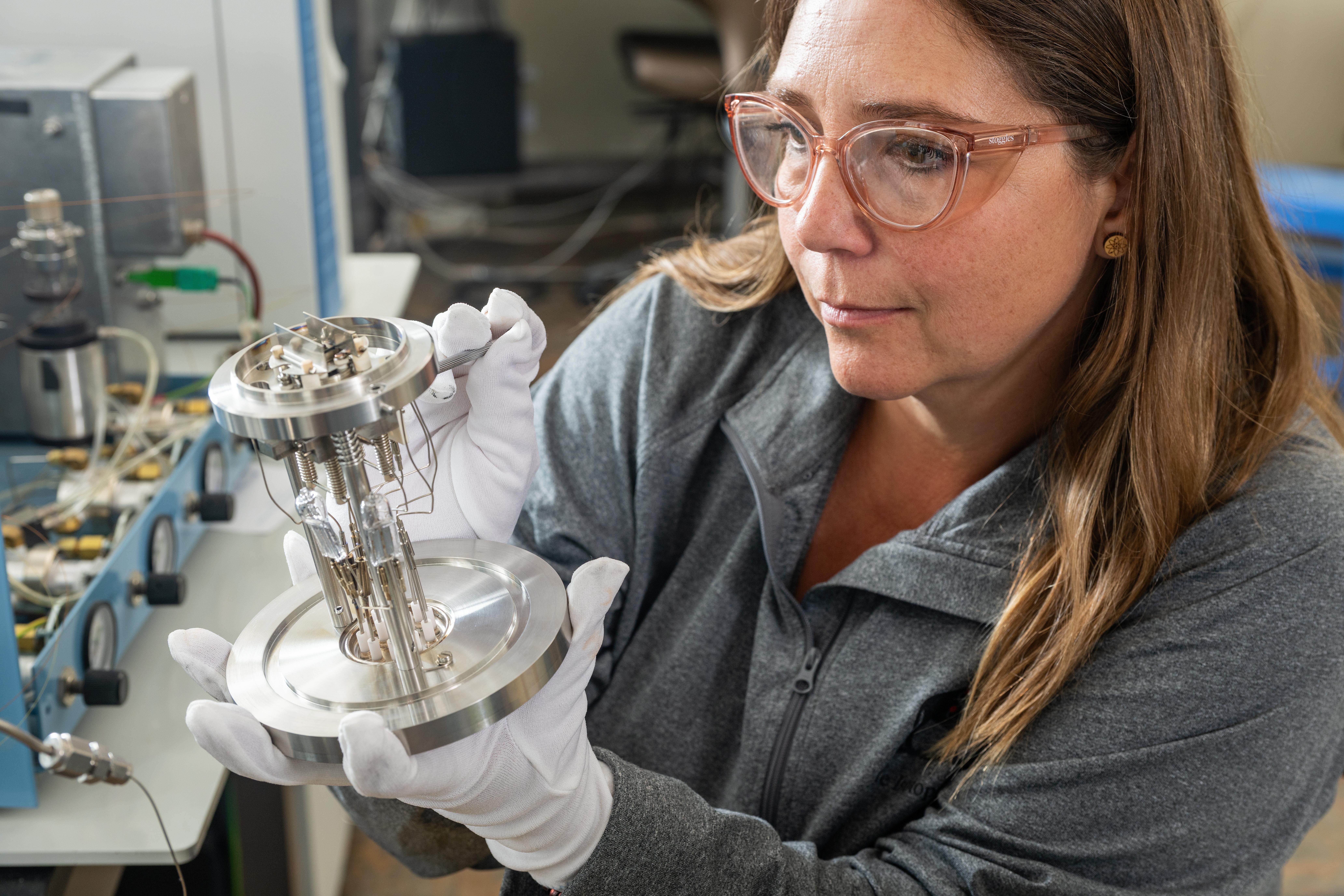 Scientist holding the heart of the instrument composed of metal plates