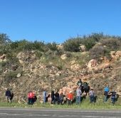 Group of teachers in the field exploring a roadside rock formation