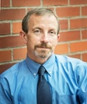 photograph of Dr. Robert Schuhmann in front of a brick wall